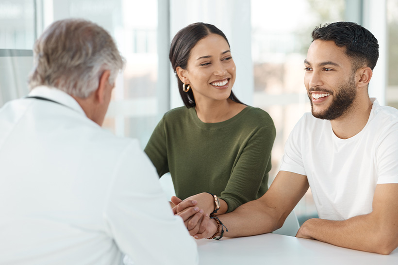 A man and woman consult with a doctor in a medical office
